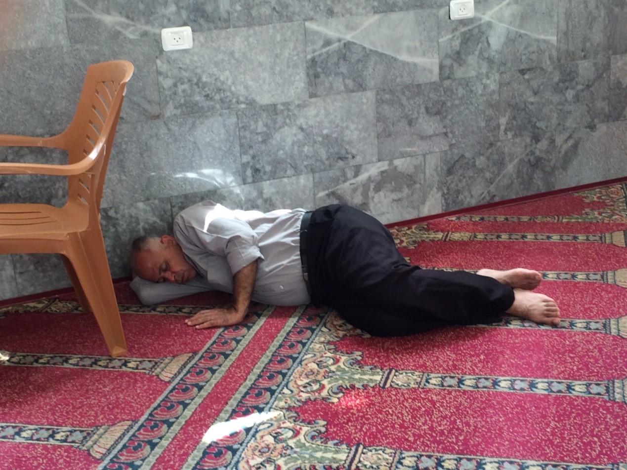 Homeless Gaza man sleeps against wall of mosque