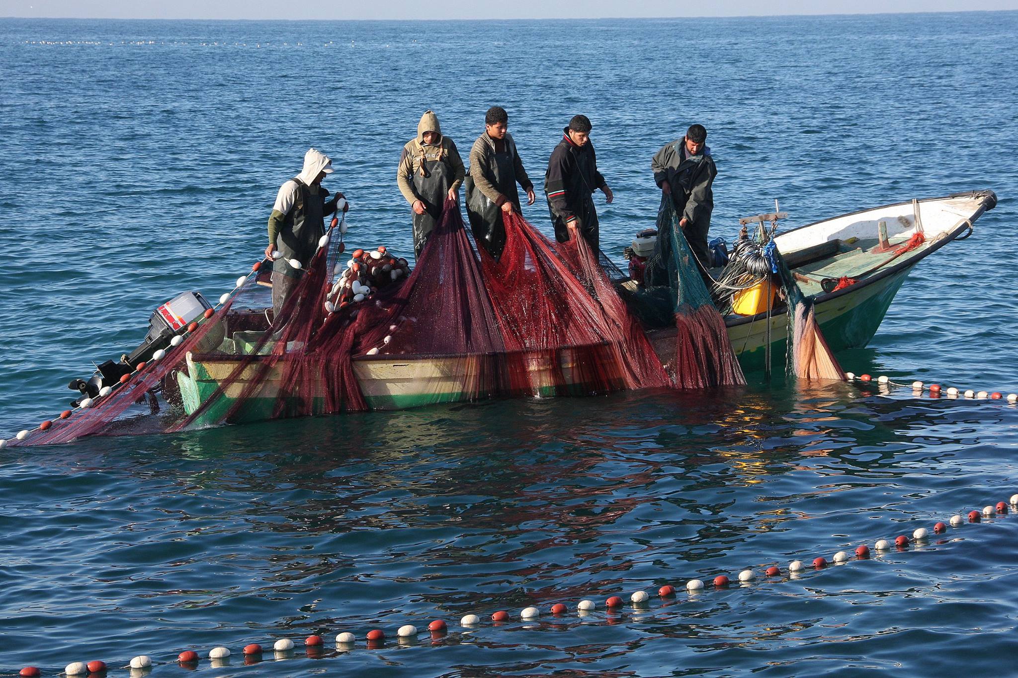 Gaza fishermen work with nets