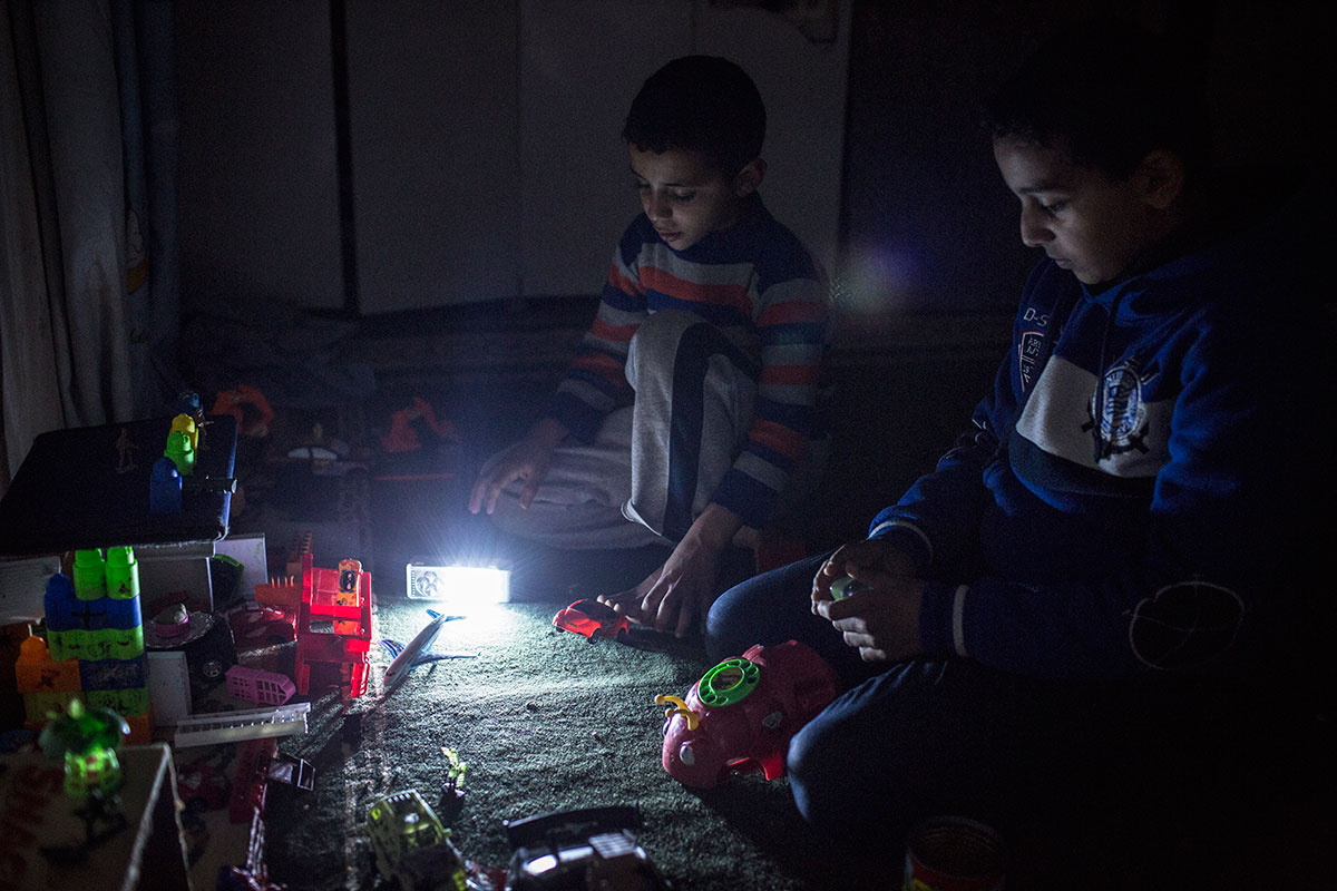 Gaza children try to study in dim candlelight