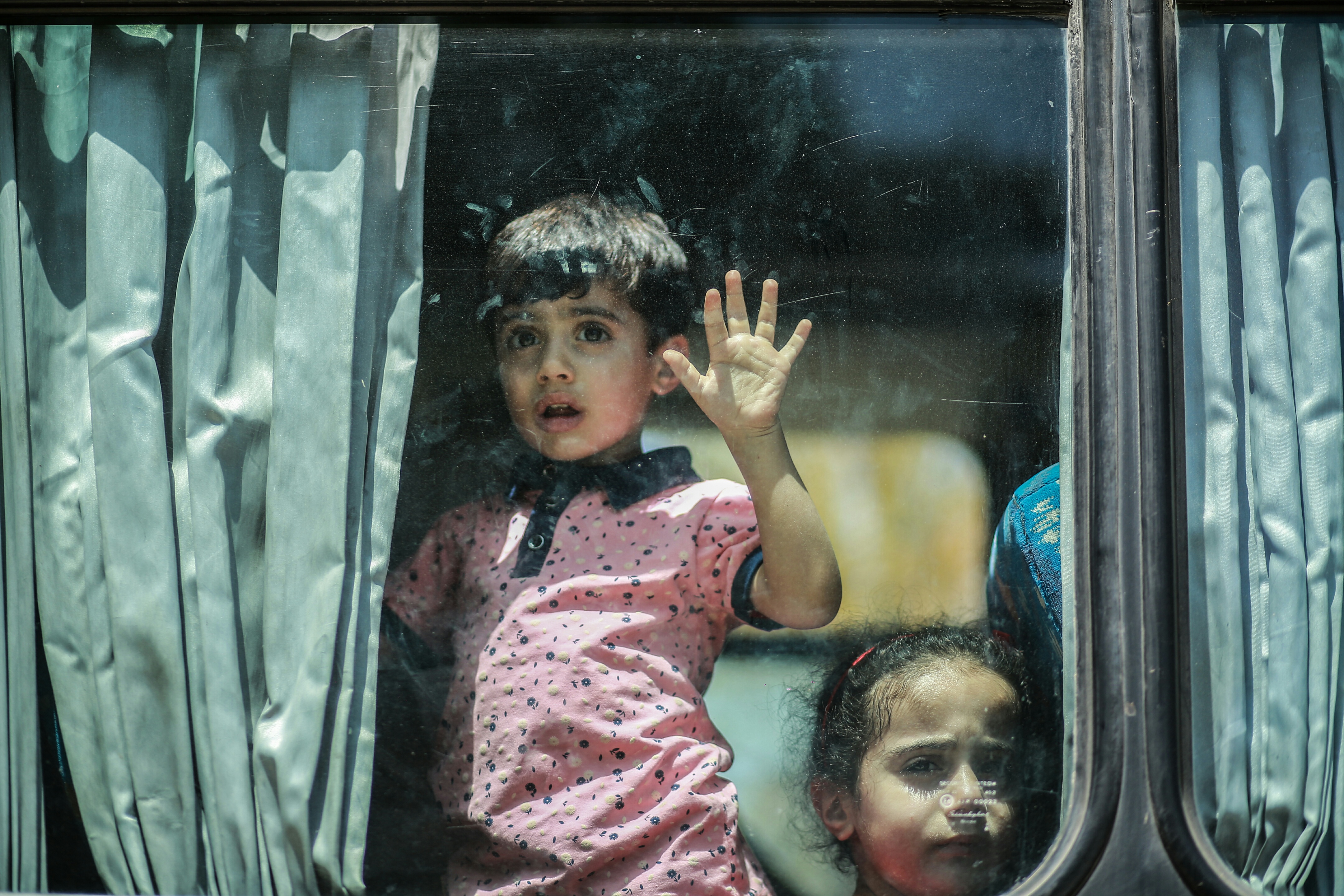 A boy from Gaza looks out the window of the bus on the way to the Egyptian border