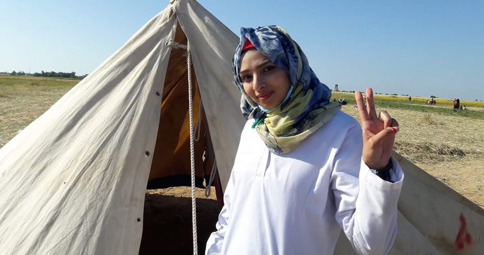 Razan flashing the peace symbol