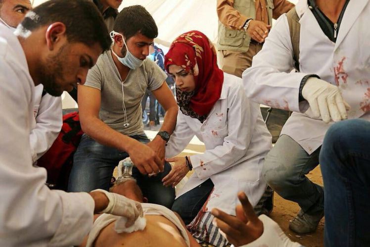 Razan treating a wounded protester in a tent.