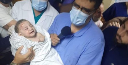 injured baby held by medical staff
