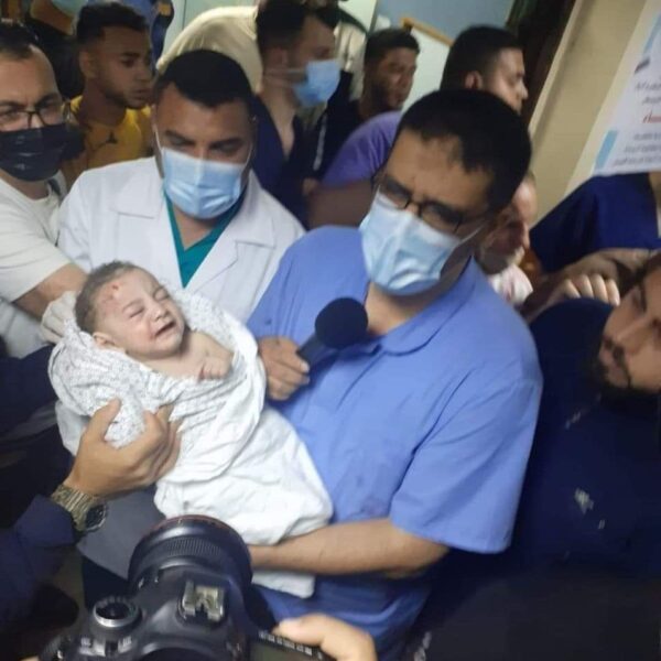 injured baby held by medical staff