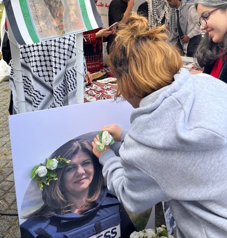 Young people decorating photo of Shireen Abu Akleh.