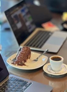 Coffee and pastry next to laptop.