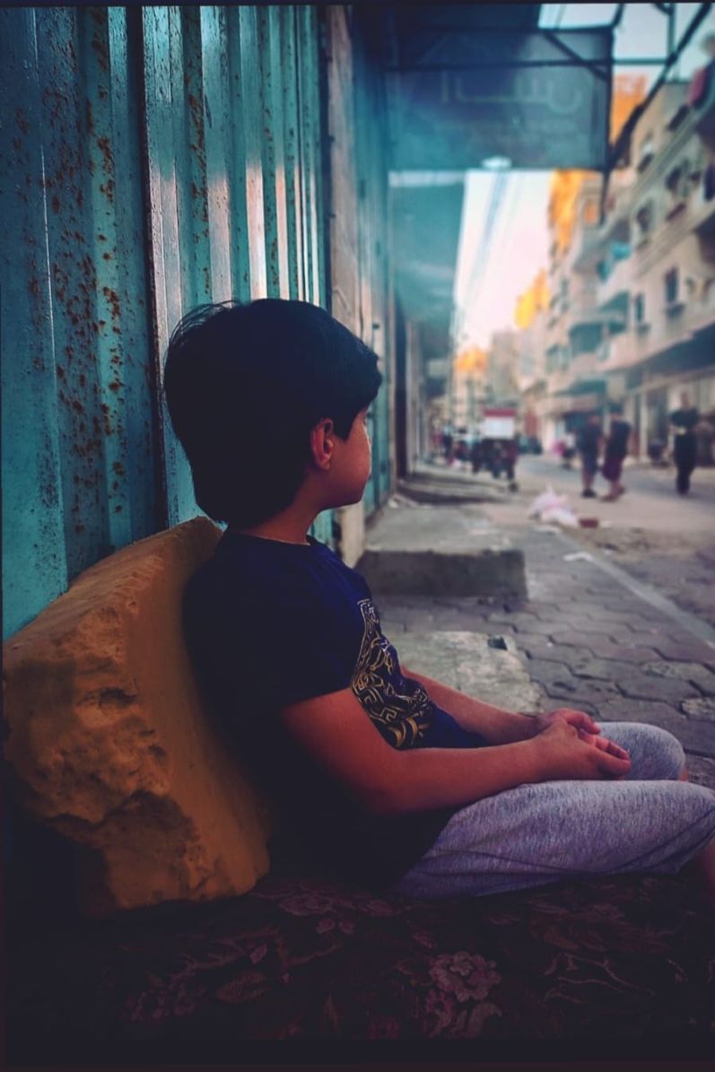 Boy waiting on street in Gaza.