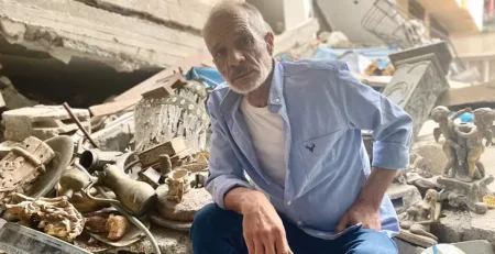 Hazem Muhanna sits amid the rubble of his home