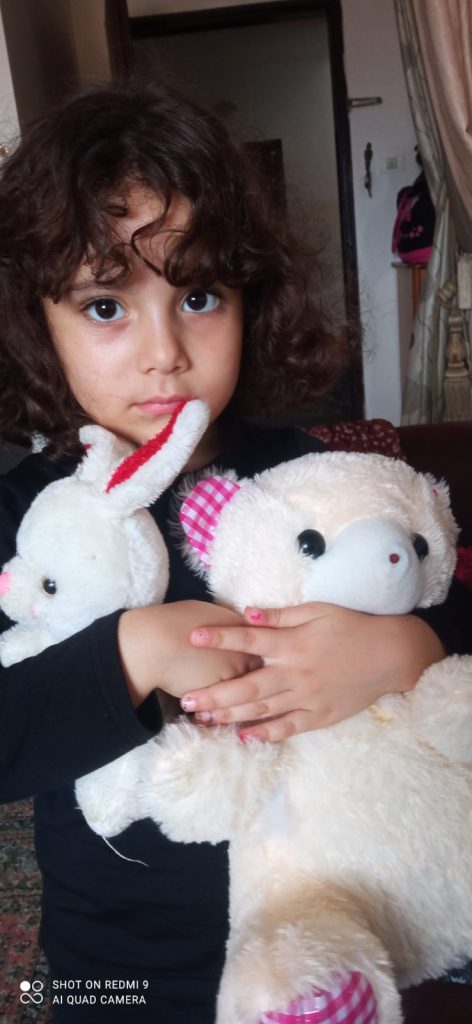 Little girl with stuffed animals.