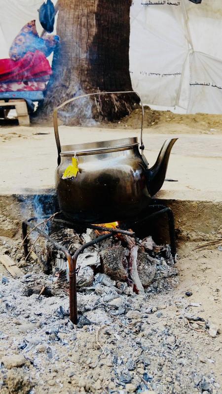 Tea kettle on outdoor fire.