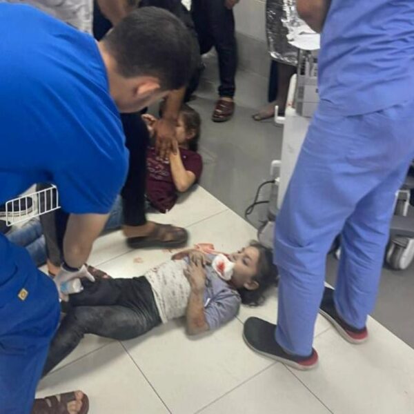 Medical worker treating child on floor of hospital.