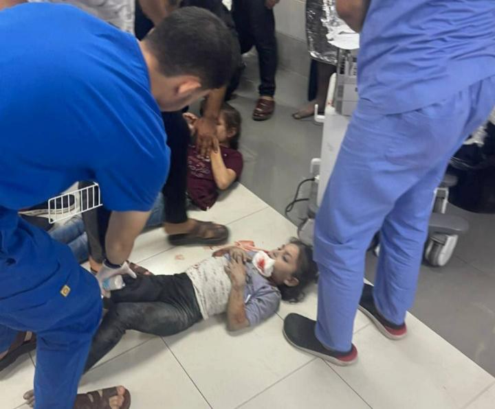 Medical worker treating child on floor of hospital.