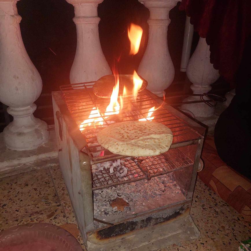 Bread baking in woodfire oven, Gaza.