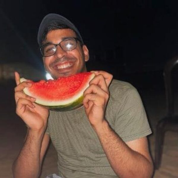 Young man eating watermelon.