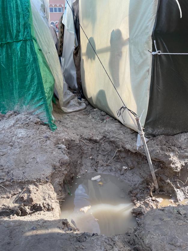 Muddy hole by tents.