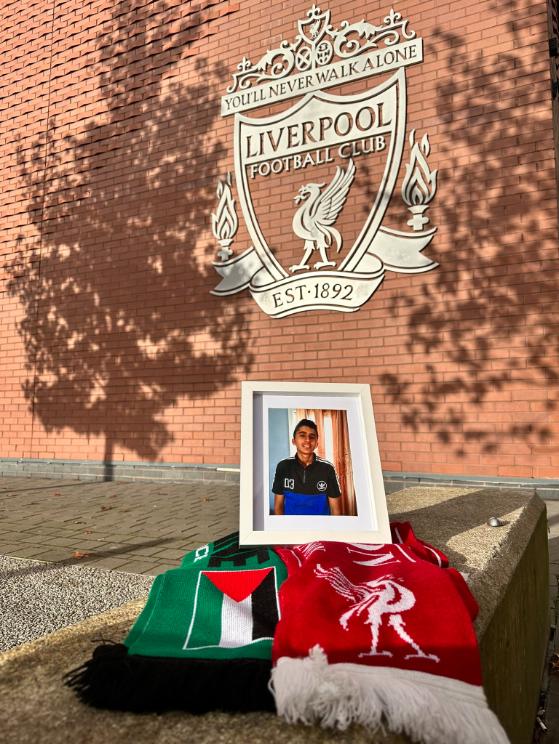 Photo of a Palestinian boy in front of Liverpool club.