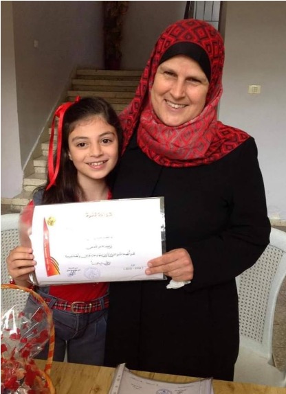 Teacher with student who is holding a certificate.