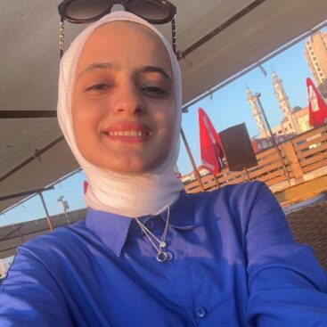 Esraa Abo Qamar in a hijab with sunglasses on her head.