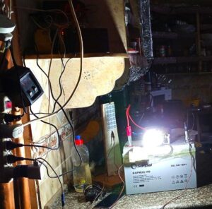 A solar-powered light in a kitchen, near an outlet with many devices plugged in.