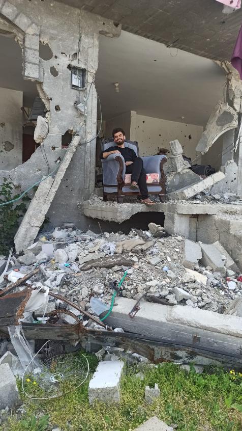 Sitting in the rubble of his home. Photo: Momen Alsammak