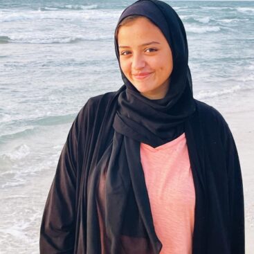 Young woman in hijab on the beach.