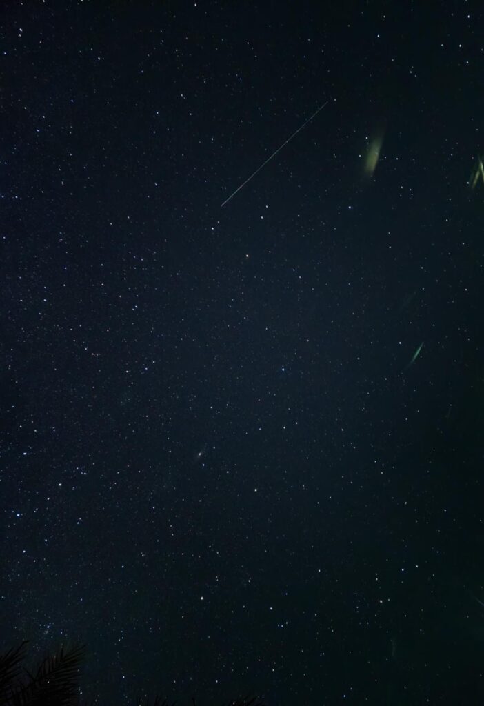 The night sky with only stars and comet streaks visible.