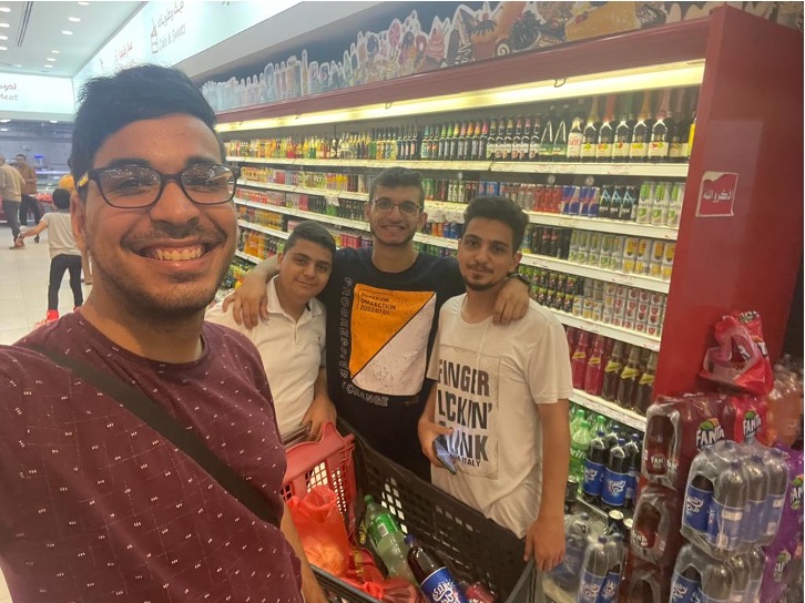 Four friends in front of convenience store shelves.