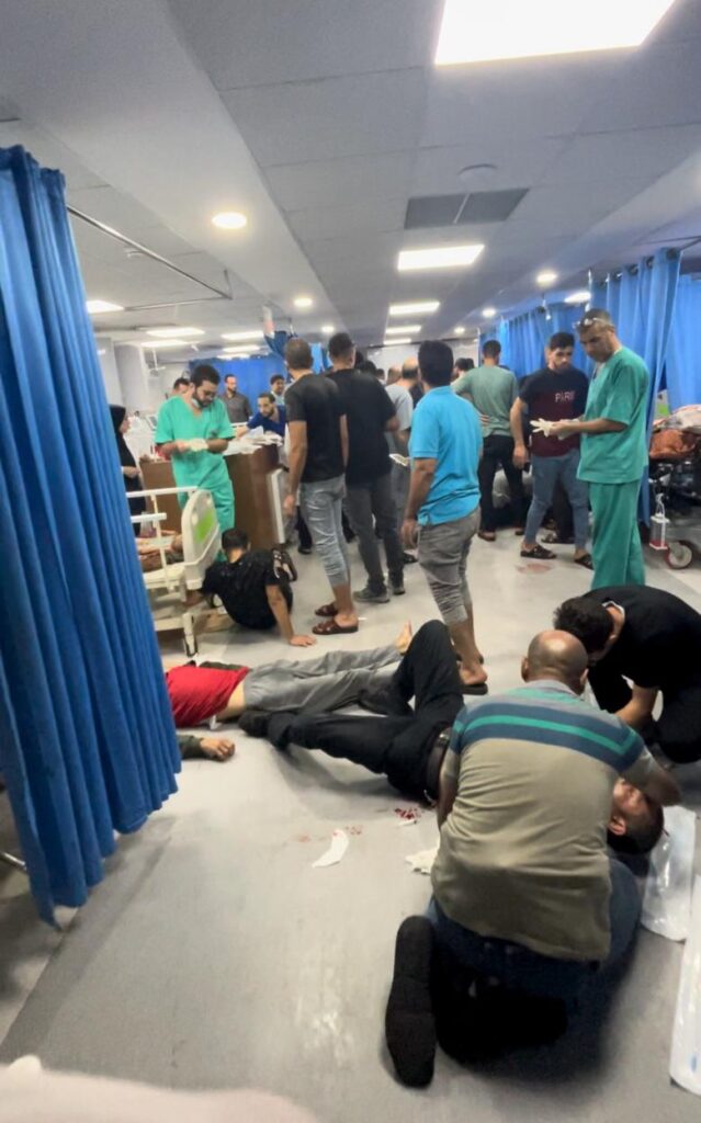 A chaotic hospital scene with patients being treated on the floor.