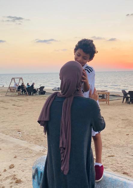 Mother holding little boy on the beach in Gaza.