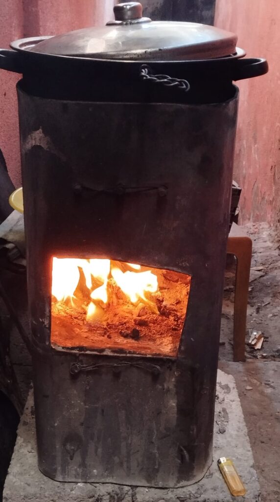 An improvised stove with fire burning in the open door.