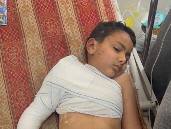 Injured boy with bandaged shoulder and arm.